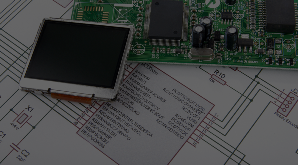 A photo of a screen and a circuit board sitting on top of a schematic